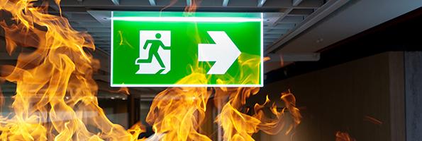 Green Fire Escape Sign Hang On The Ceiling In The Office.